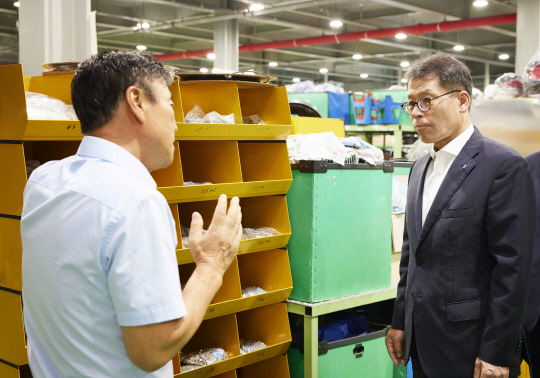 지난 12일 김성태 기업은행장(오른쪽)이 경기 시흥에 위치한 경서글로텍을 방문해 김재홍 대표로부터 작업 공정에 관한 설명을 듣고 있다. 기업은행 제공.